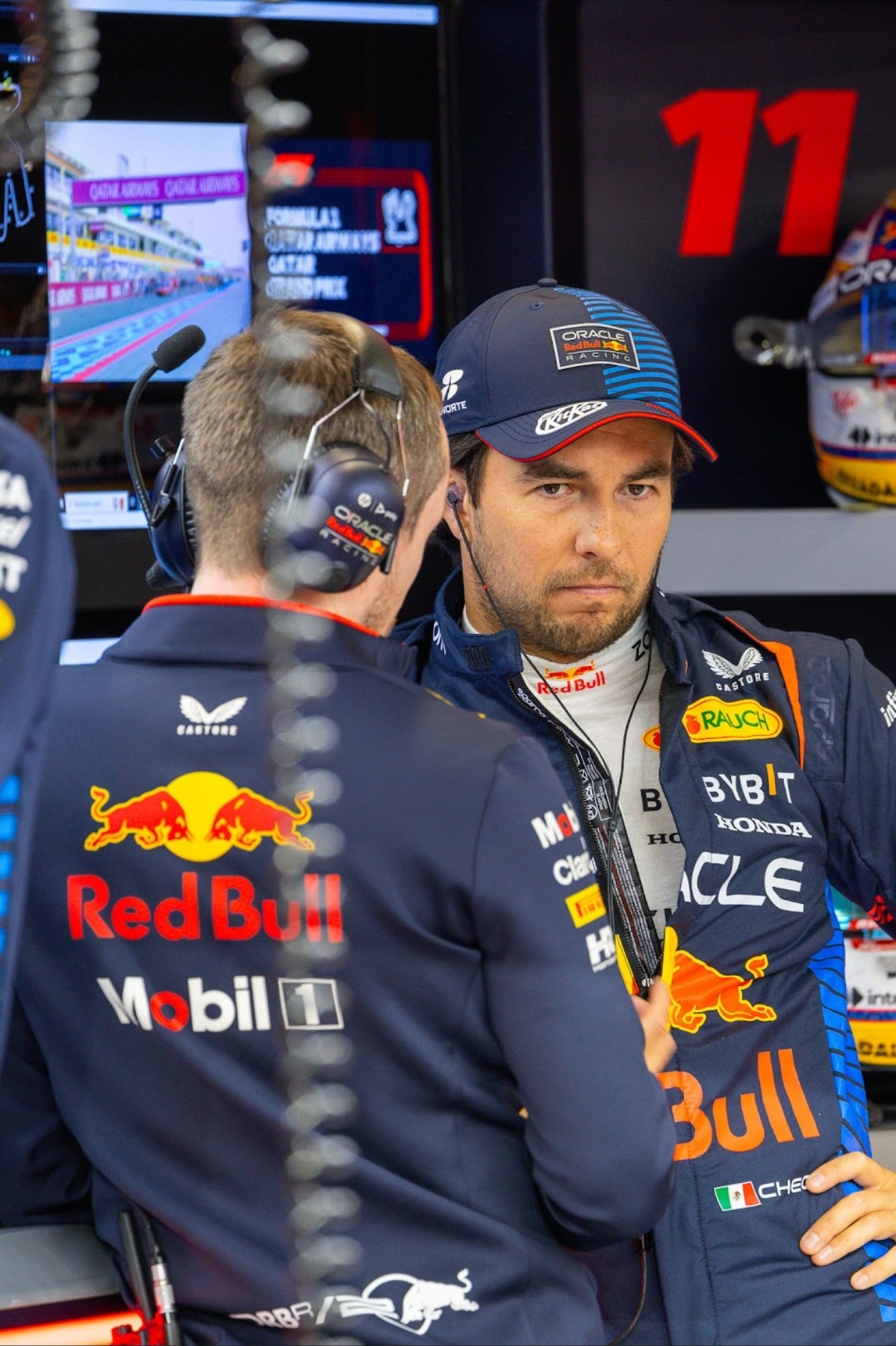 Sergio Pérez providing technical feedback to Cadillac F1 engineers in the garage, illustrating his role in building the team's technical foundation for the 2026 season.