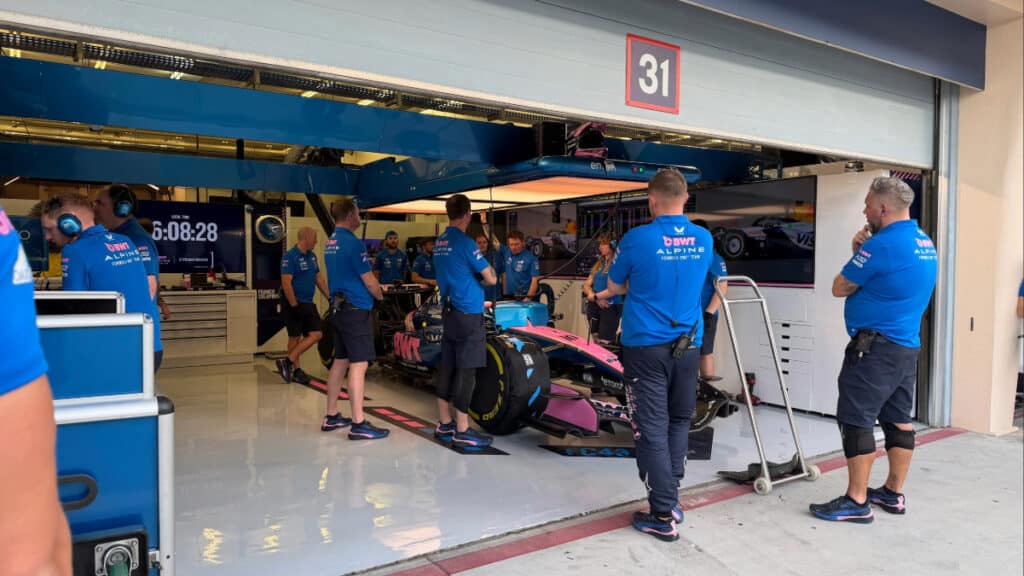 Alpine mechanics and engineers gathered in the garage during the final stages of the 2026 Bahrain pre-season test to analyze late-session data.