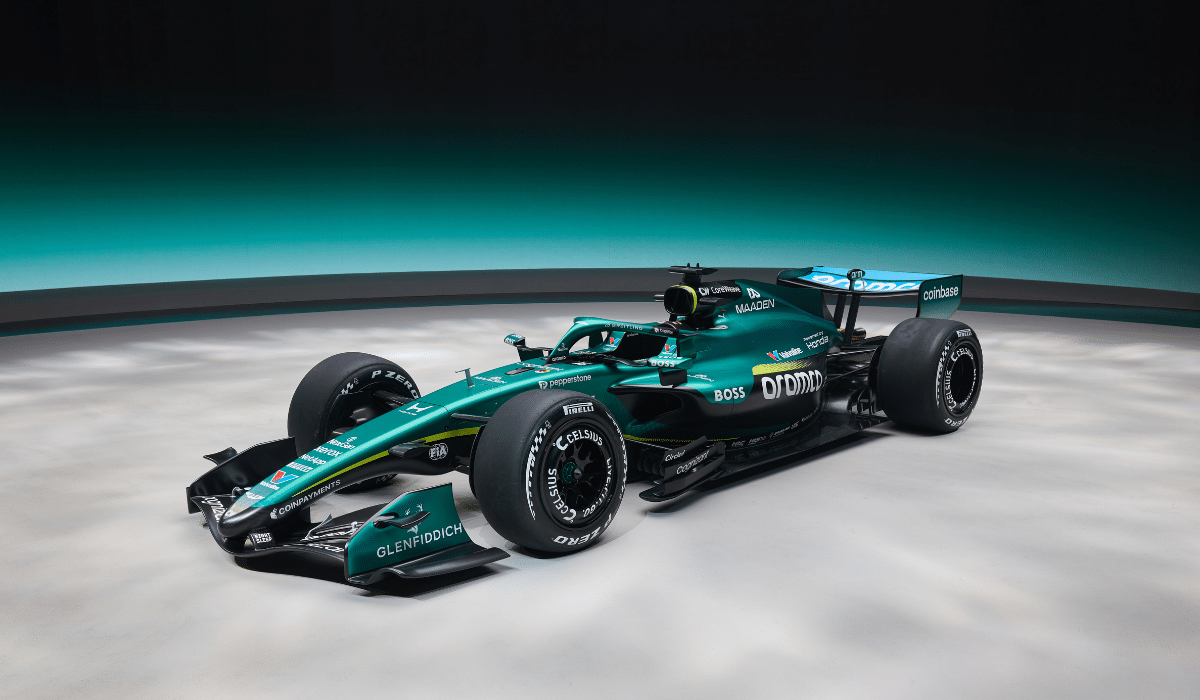 The Aston Martin AMR26 Formula One car on display during its 2026 launch event, featuring matte British Racing Green livery and Aramco blue accents.