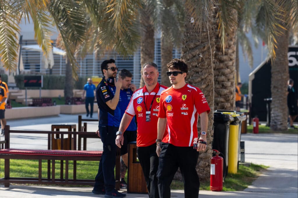 Ferrari driver Charles Leclerc walking through the Bahrain paddock during the final day of 2026 pre-season testing, following his benchmark "power hour" performance.