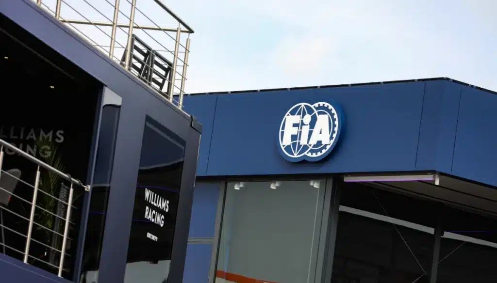 The official FIA logo on a building in the Formula One paddock, representing the governing body's regulatory oversight.