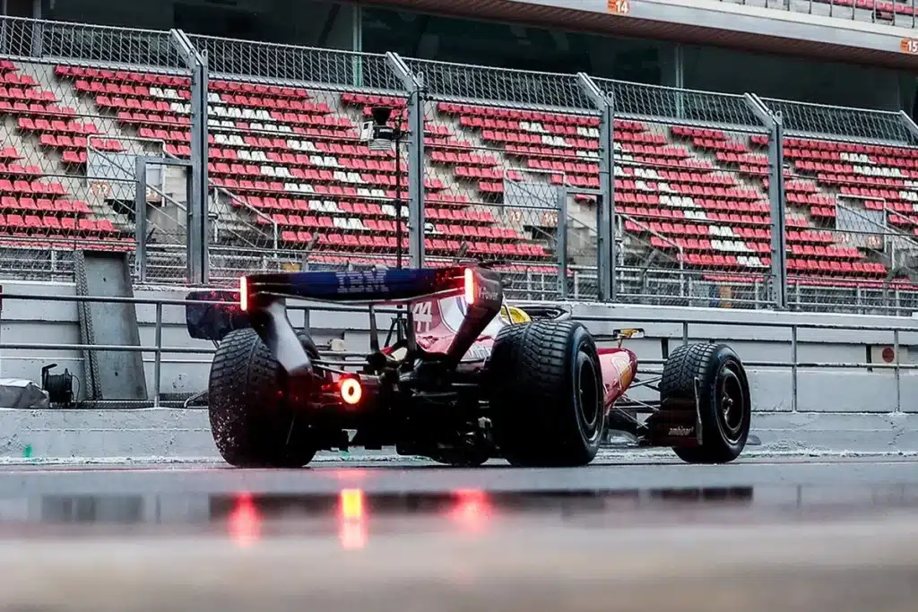 Rear view of Lewis Hamilton's Ferrari SF-26 with wet weather tires and rain lights on at the Circuit de Barcelona-Catalunya.