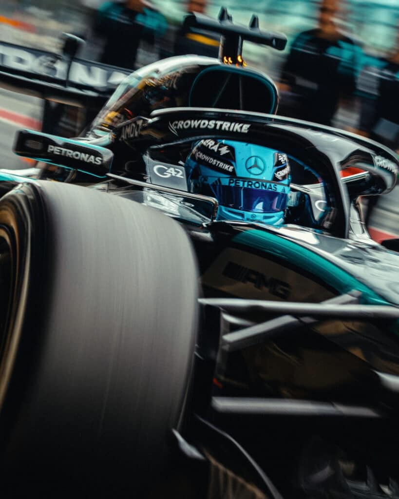 A close-up action shot of George Russell in the Mercedes W15, showcasing the aerodynamic geometry and high-speed performance on track.