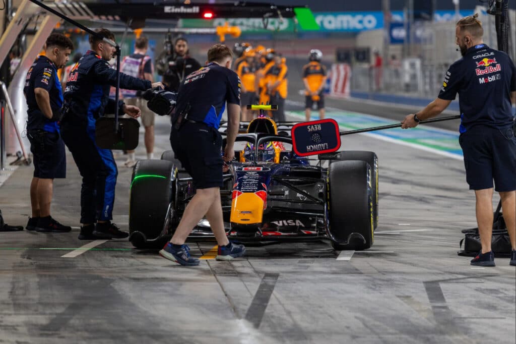 Red Bull Racing mechanics work on the RB22 in the Bahrain pit lane during 2026 pre-season testing, showcasing a measured and disciplined program.