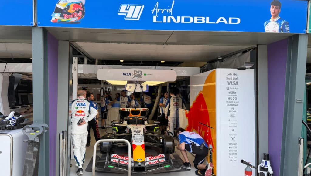 Arvid Lindblad speaking with Racing Bulls team members in the pit lane at Albert Park.
