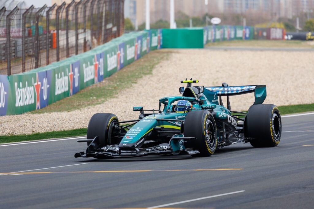 The Aston Martin AMR26 car on track during the 2026 Chinese Grand Prix, where persistent power unit and vibration issues hampered the team's performance.