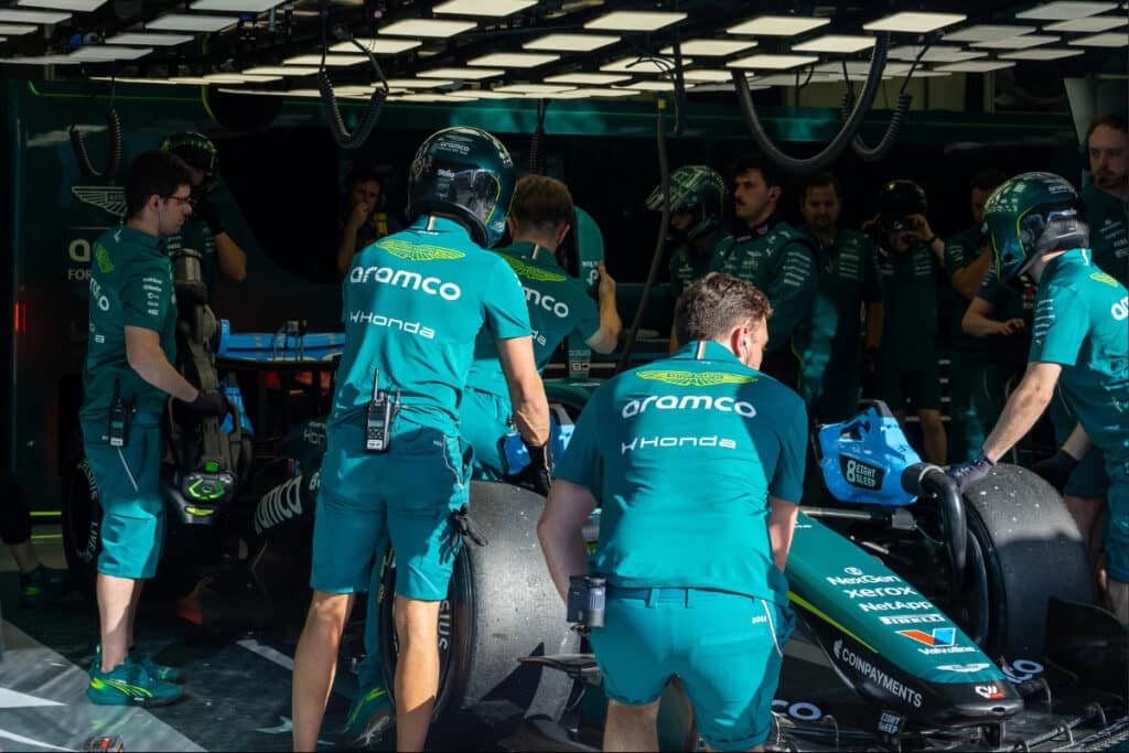 Aston Martin mechanics in the Albert Park garage working on the AMR26 chassis and rear assembly to investigate vibration issues.