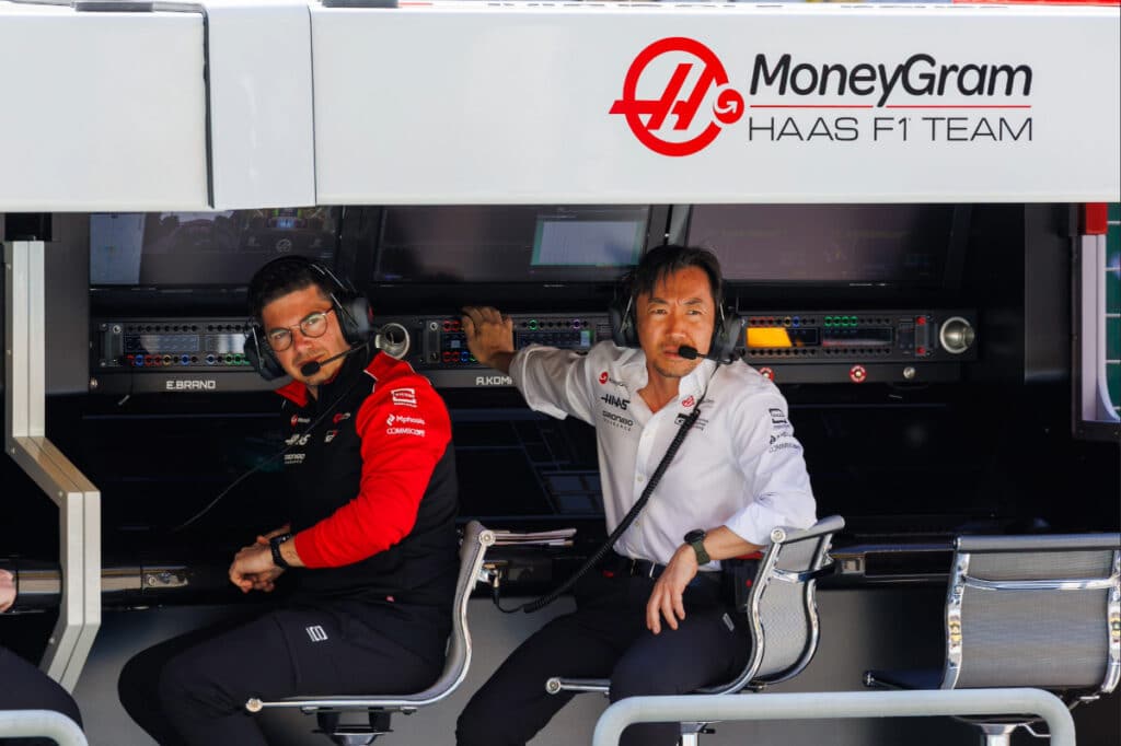 Haas Team Principal Ayao Komatsu wearing a headset and monitoring telemetry screens on the pit wall at the Australian Grand Prix.