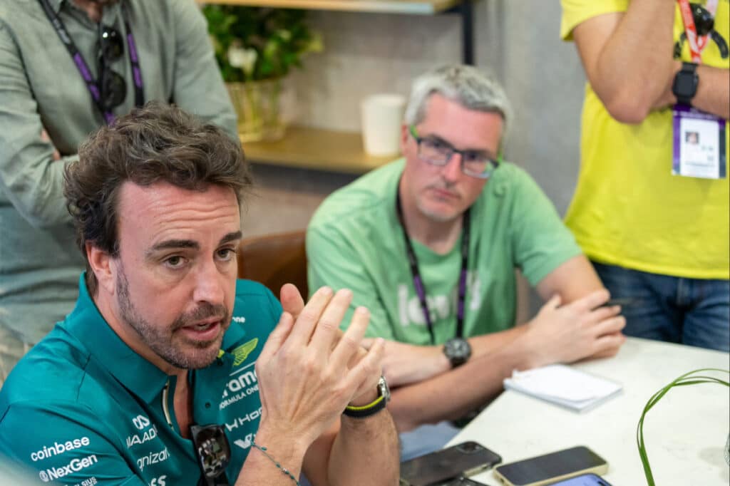 Fernando Alonso gesturing while discussing the Aston Martin AMR26 technical issues and vibration solutions at the Australian Grand Prix.