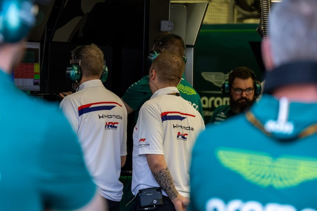 Honda HRC engineers and Aston Martin team members work together in the garage to address power unit reliability and structural vibration issues during the 2026 F1 season.