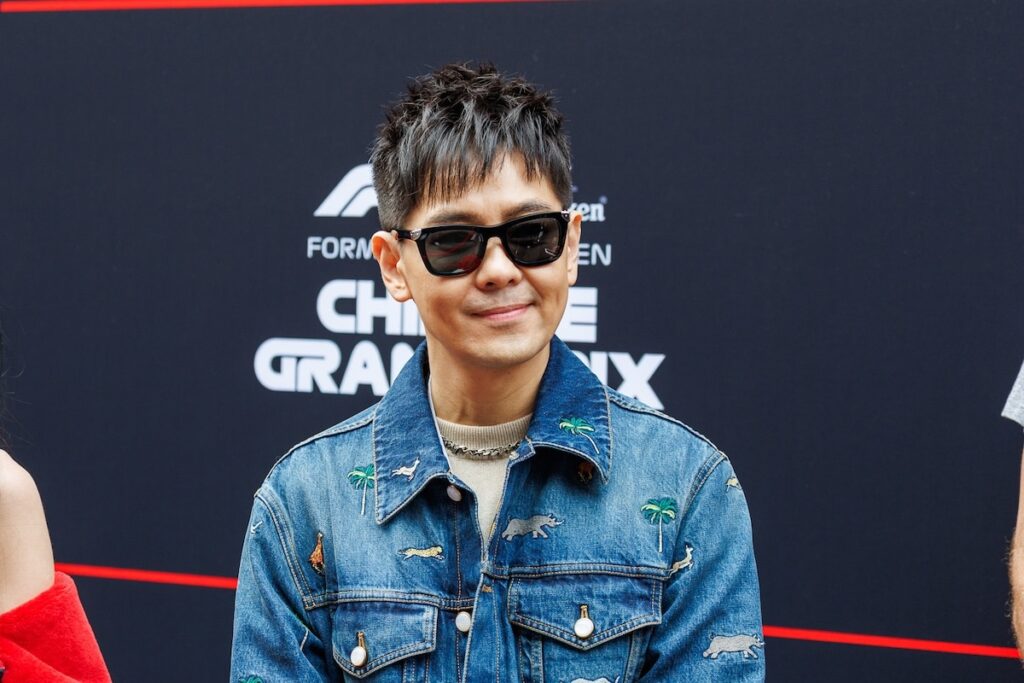 Taiwanese entertainer and racing fan Jimmy Lin wearing a denim jacket and sunglasses at the 2026 F1 Chinese Grand Prix.