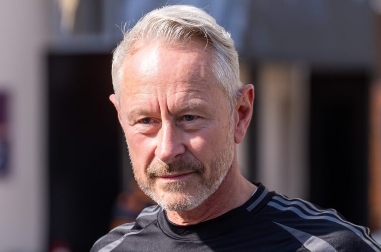 A close-up portrait of Jonathan Wheatley, formerly of Audi F1, looking thoughtful amidst intense speculation regarding his move to Aston Martin in 2026.