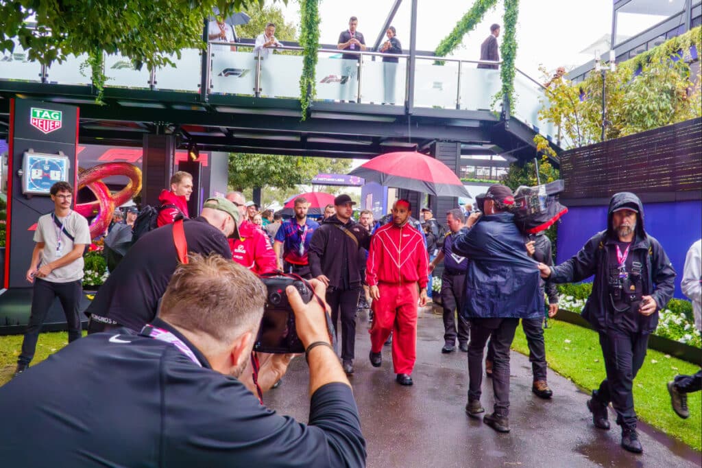 Lewis Hamilton walking through the Melbourne Walk at Albert Park, surrounded by fans and photographers during the Australian Grand Prix weekend.
