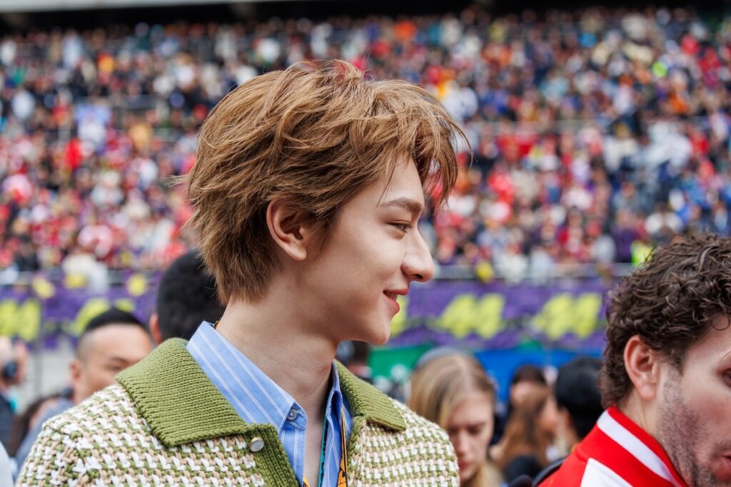 Chinese actor and singer Li Yunrui smiling in the paddock area during the 2026 F1 Chinese Grand Prix in Shanghai.