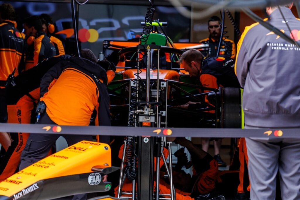 McLaren F1 mechanics working intensely on the car in the Shanghai garage following a rare double non-start technical failure during the 2026 Chinese Grand Prix.