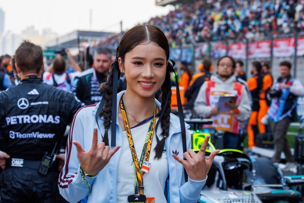 Thai actress Prim Chanikarn posing on the starting grid in front of the Mercedes-AMG PETRONAS F1 car at the 2026 Chinese Grand Prix.